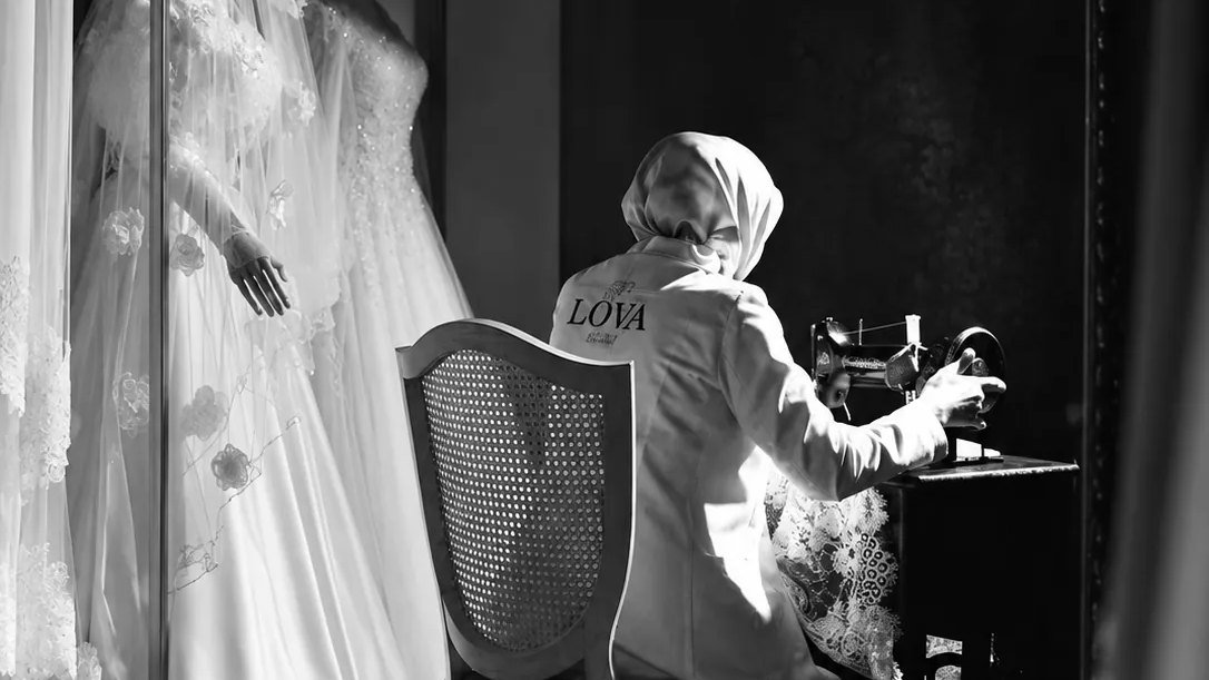 LOVA atölyesinde dikiş makinesinde çalışan terzi ve mankenlerde gelinlikler
